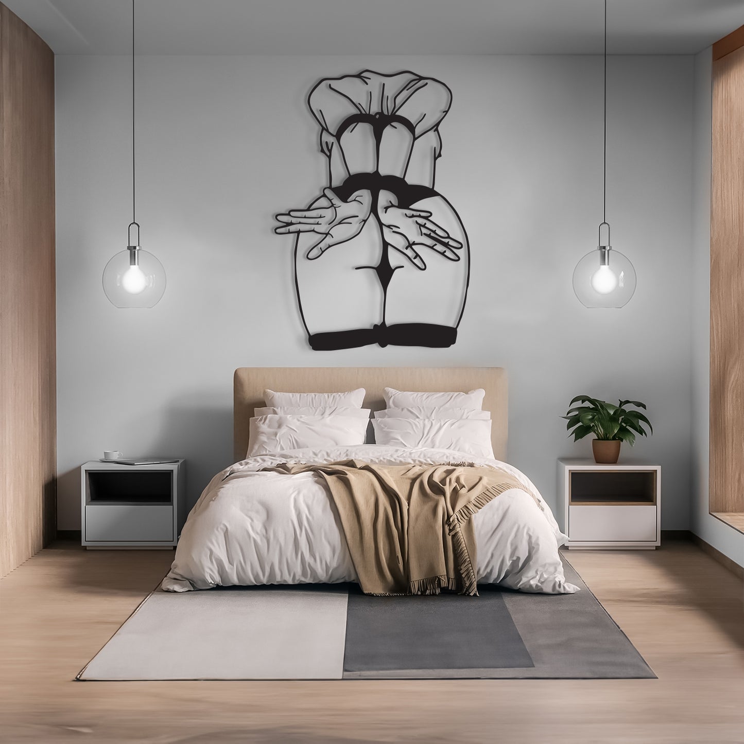 A modern bedroom interior with a bed dressed in white bedding and a beige throw blanket, flanked by two white nightstands and a gray area rug. A black metal wall art piece depicting a stylized female torso is mounted on the light gray wall above the headboard.