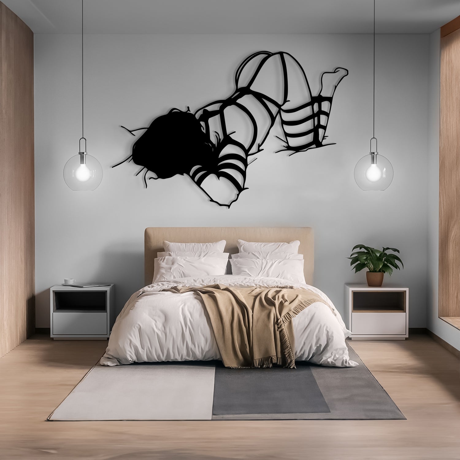 A modern bedroom interior with a bed dressed in white bedding and a beige throw blanket, flanked by two white nightstands and pendant lights. A large black abstract wall sculpture is mounted above the bed on a light gray wall.