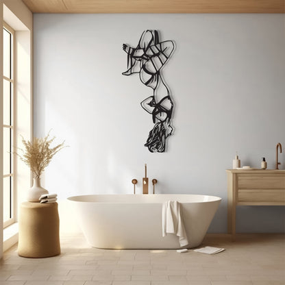 A modern freestanding bathtub in a bright, minimalist bathroom with a light gray wall, black abstract wall art, a wooden vanity, and a window on the left.