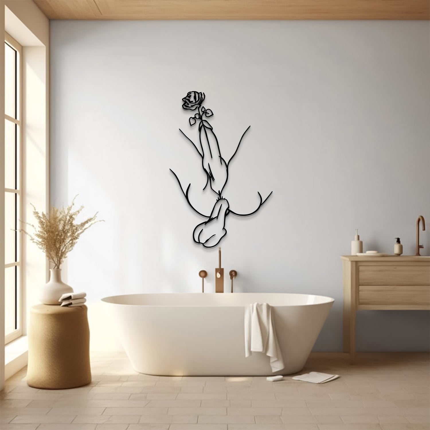 A minimalist black metal wall art piece depicting a woman with a rose, mounted on a light gray wall above a freestanding white bathtub in a bright, modern bathroom.