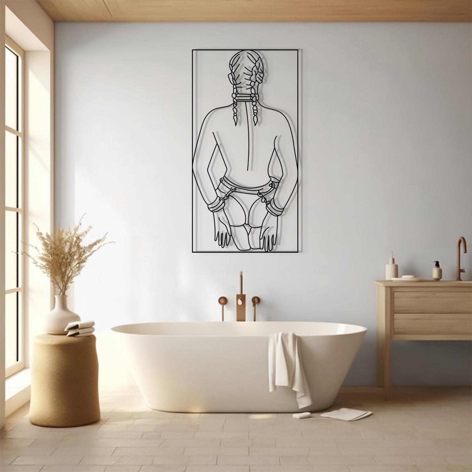 A minimalist black line art print of a woman's back with braided hair, displayed on a light gray wall above a white freestanding bathtub in a modern, sunlit bathroom.