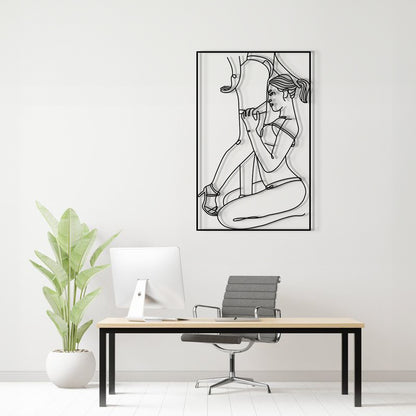 A black and white line art poster of a woman in a bikini hanging on a light gray wall above a modern desk setup with a computer, chair, and a potted plant.