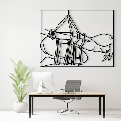 A minimalist black line art print of a hammock hanging over a reclining figure, displayed on a white wall above a modern desk setup with a computer, chair, and potted plant.