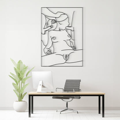 A minimalist black and white continuous line art print of a nude female figure is displayed on a white wall above a modern desk setup with a computer, chair, and a potted plant.