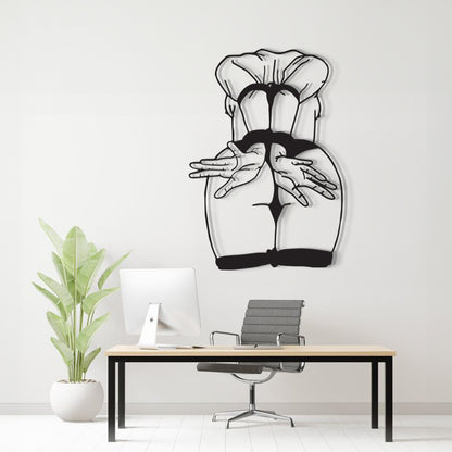 A black and white line art wall decal depicting a stylized female figure from behind, displayed on a light gray wall above a modern desk setup with a computer, chair, and potted plant.