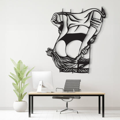 A black and white stylized wall art print of a woman lifting her skirt, displayed on a light gray wall above a modern desk setup with a computer, chair, and potted plant.