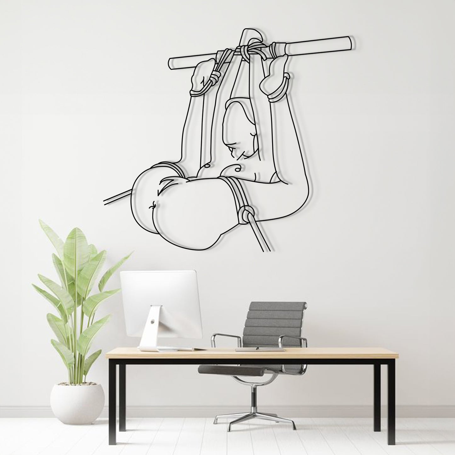 Wall decal of a person in a hammock above a desk with a plant and chair.