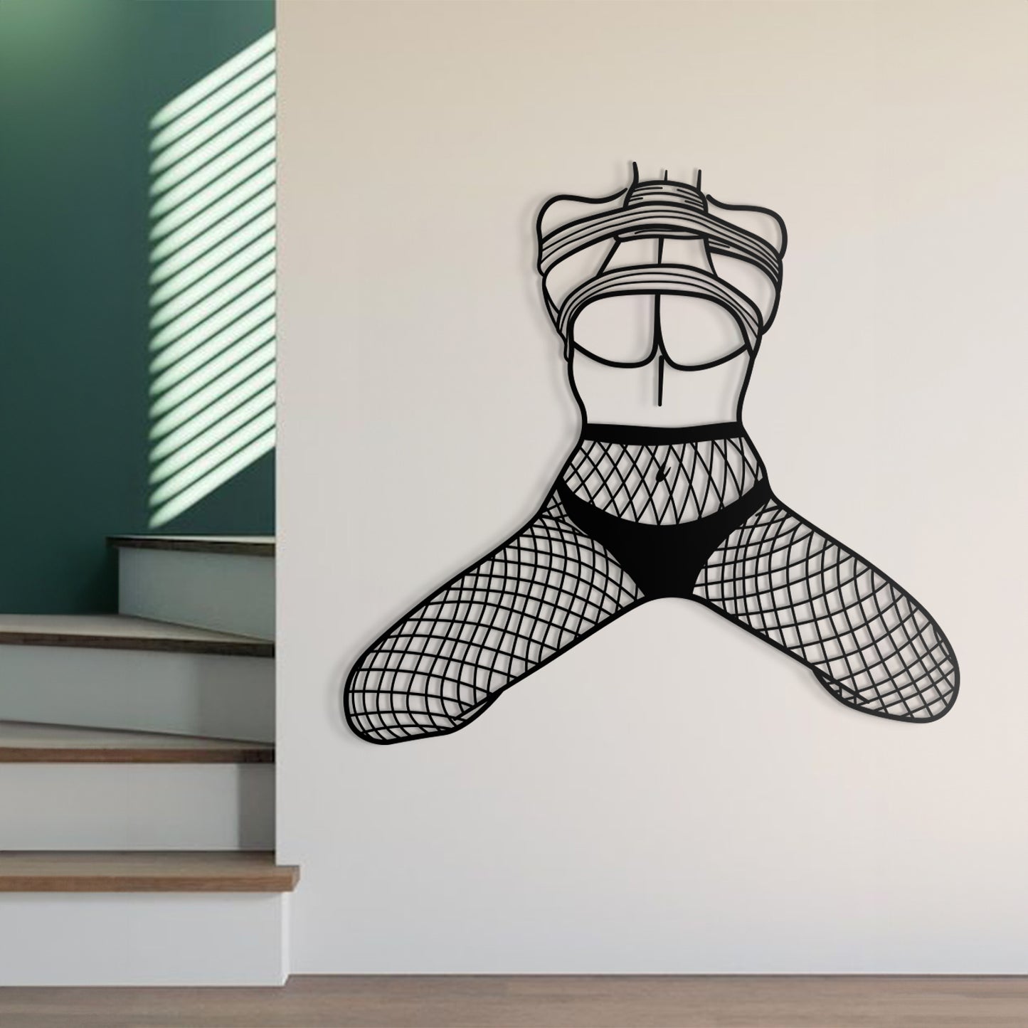 Black wall decal of a stylized figure on a white wall with stairs in the background.
