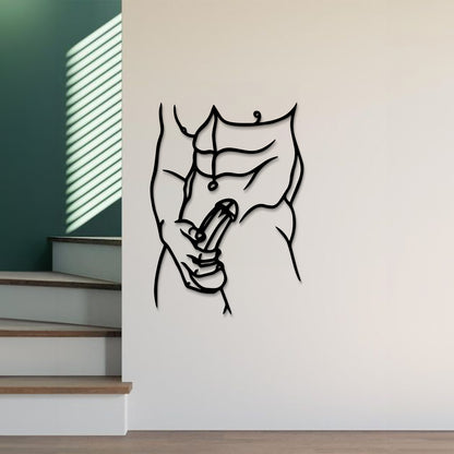 A minimalist black metal wall art piece depicting a muscular torso and hand holding a penis, mounted on a white wall in a modern interior setting with stairs and window blinds visible.