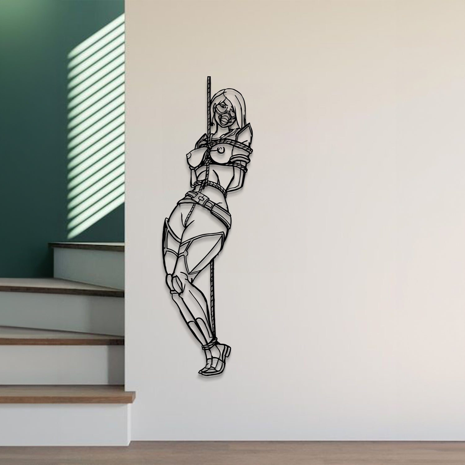 A black line art wall decal of a female ninja figure hanging on a light beige wall in a modern room setting next to a staircase.