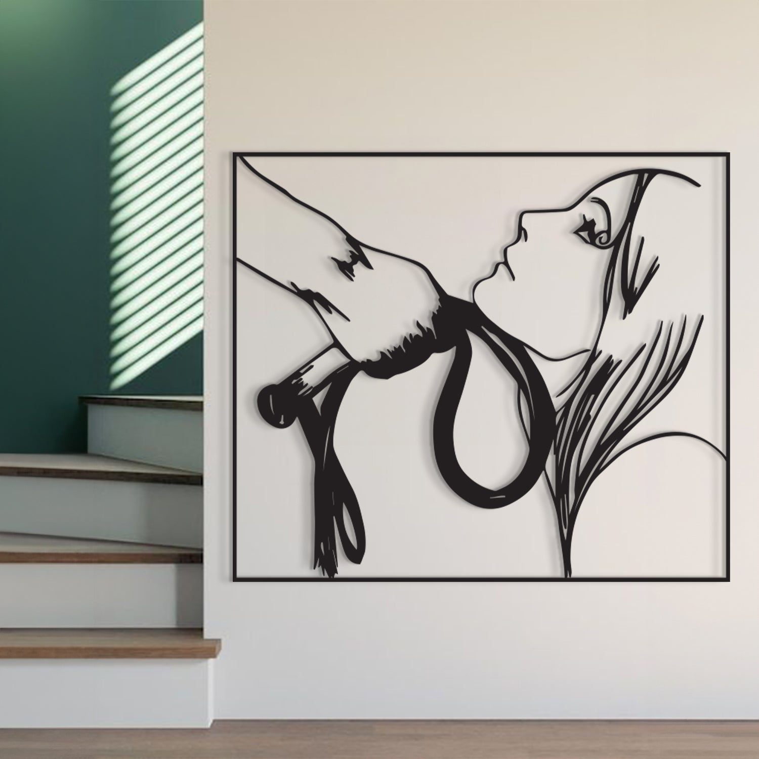 A black metal wall art piece depicting a hand holding a rope near a woman's face, displayed on a white wall next to a staircase.