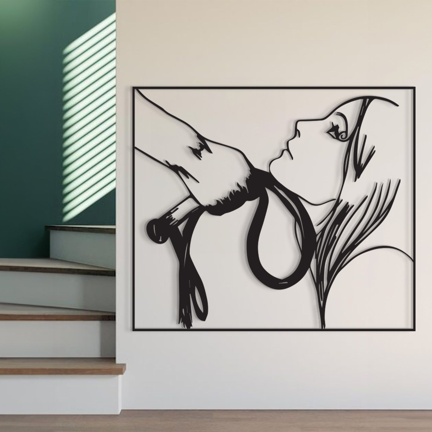 A black metal wall art piece depicting a hand holding a rope near a woman's face, displayed on a white wall next to a staircase.