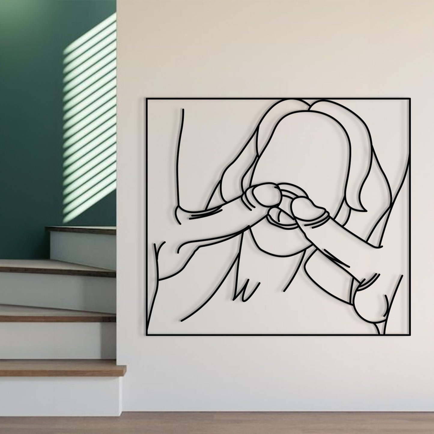 A minimalist black and white continuous line art print of a mother holding her child, displayed on a white wall in a modern interior setting with stairs and a green accent wall visible.