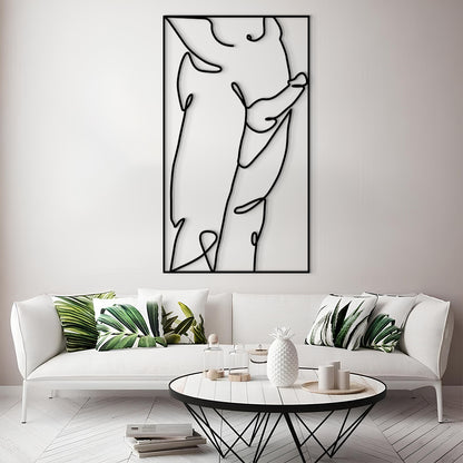 A modern living room scene featuring a large black and white minimalist line art print on a white wall above a white sofa with green leaf-patterned pillows. In the foreground is a round white coffee table with a black wire frame.