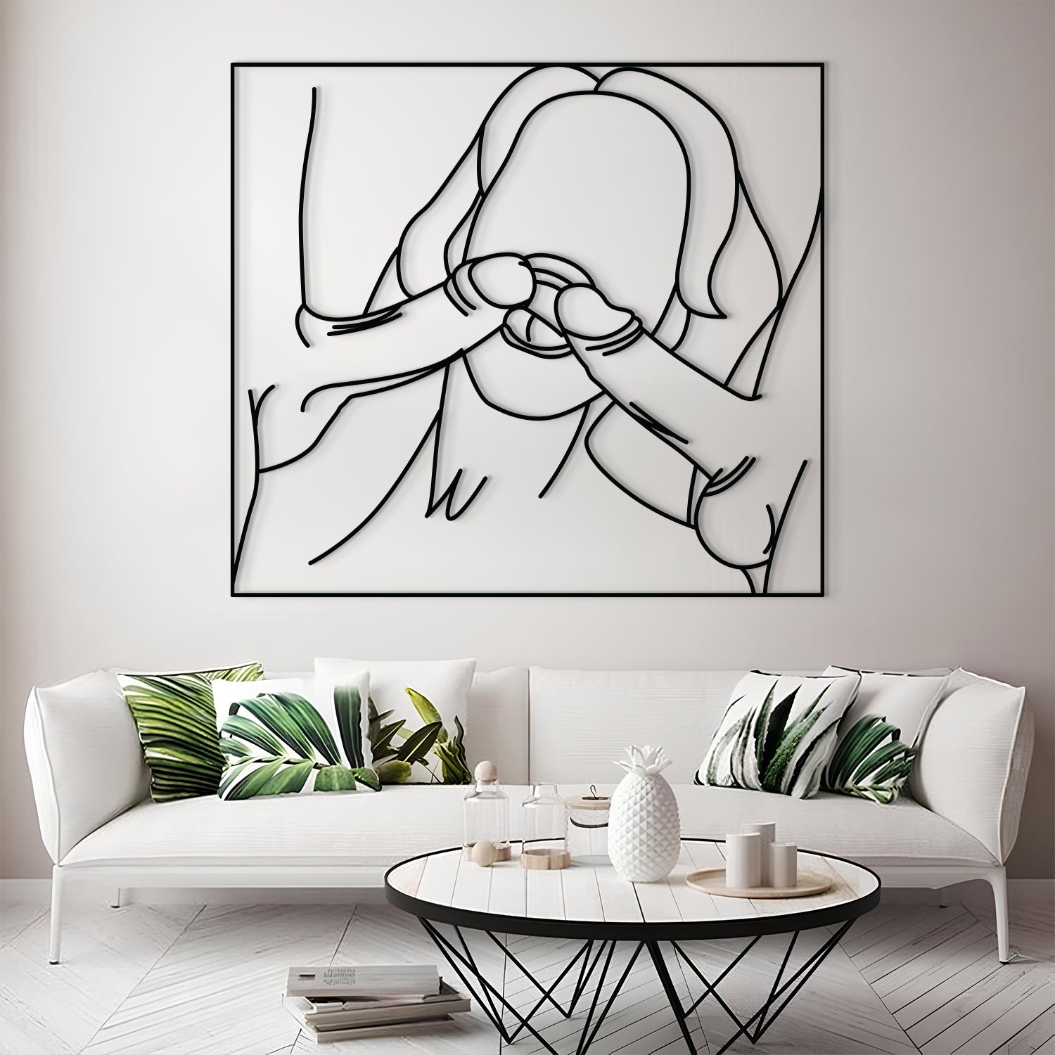 A large black metal wall art piece featuring a minimalist line drawing of a person, displayed above a white sofa in a modern living room setting.