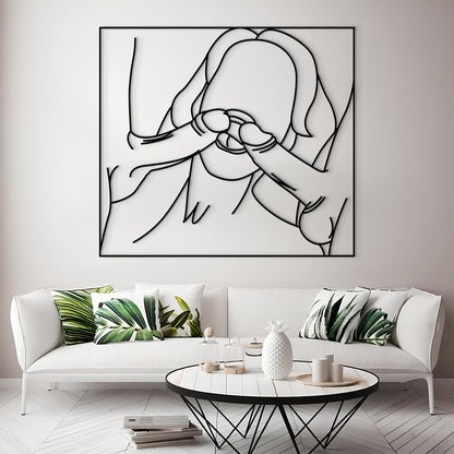 A large black metal wall art piece featuring a minimalist line drawing of a person, displayed above a white sofa in a modern living room setting.