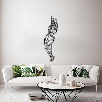 A black metal wall art piece depicting a stylized, geometric female figure hanging from a pole, displayed on a light gray wall above a modern white sofa with green leaf-patterned pillows.