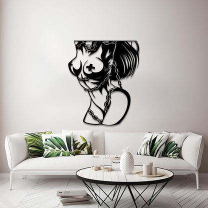 A black metal wall art piece depicting a stylized female profile with a cross motif on the breast and a heart-shaped pendant, displayed on a light gray wall above a white sofa in a modern living room setting.