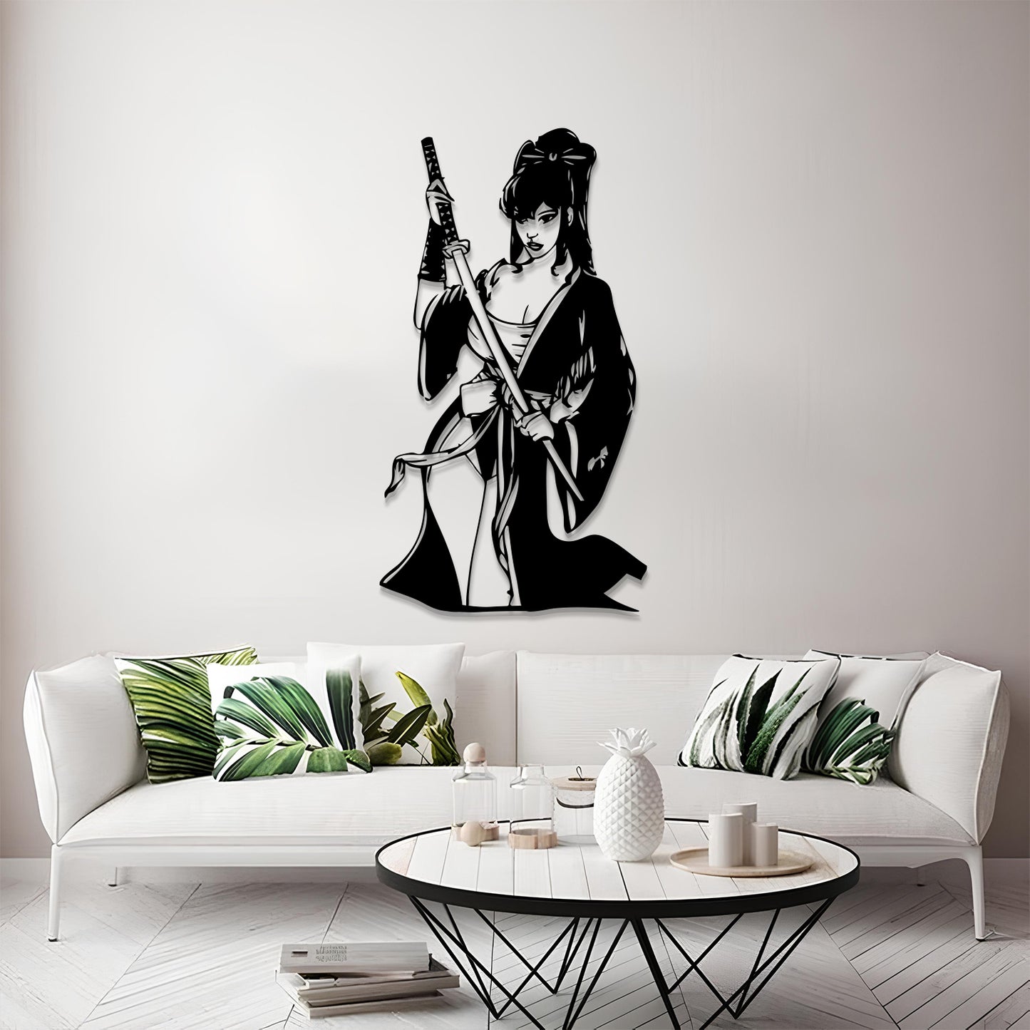 A black metal wall art piece depicting a female samurai warrior holding a sword, mounted on a light gray wall above a modern white sofa in a styled living room.