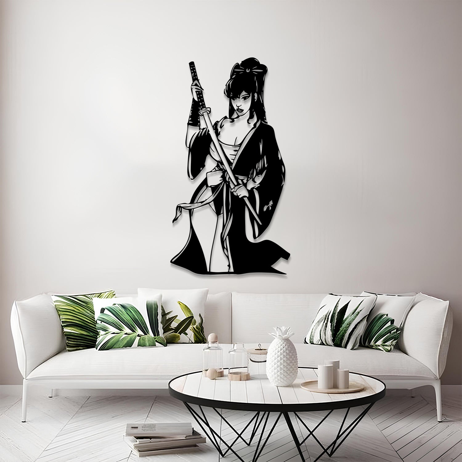A black metal wall art piece depicting a female samurai warrior holding a sword, mounted on a light gray wall above a modern white sofa in a styled living room.