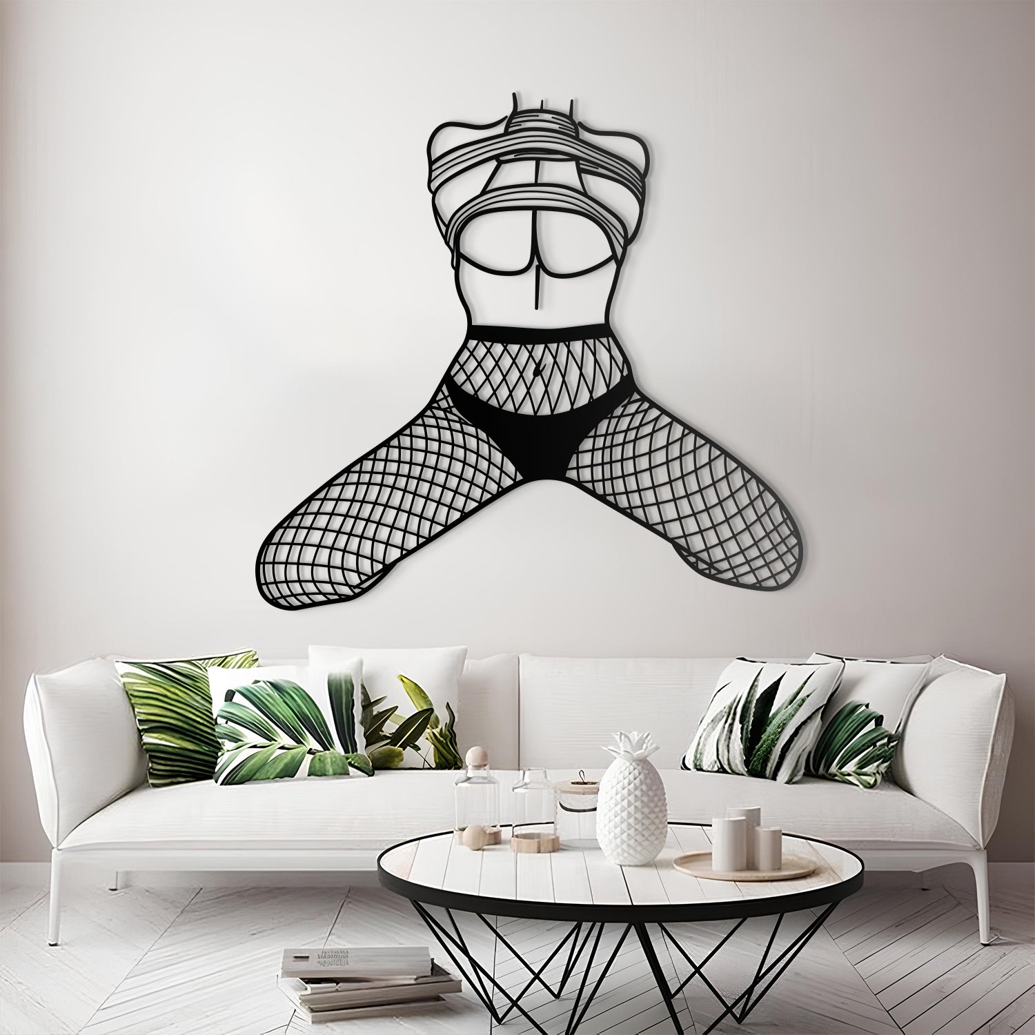 Metal wall art of a stylized female figure in a bikini on a white wall above a modern living room.