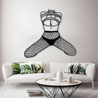 Metal wall art of a stylized female figure in a bikini on a white wall above a modern living room.