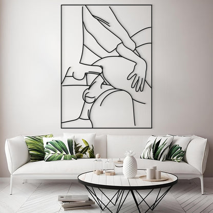 A modern living room scene featuring a large black and white minimalist line art print of a couple on the wall above a white sofa with green leaf-patterned pillows.
