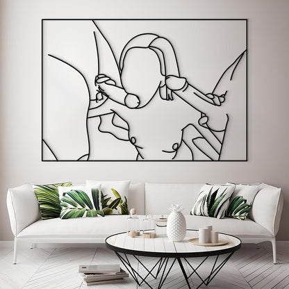 A large black and white minimalist line art wall sculpture depicting a couple embracing, mounted on a light gray wall above a modern white sofa with green leaf-patterned pillows.