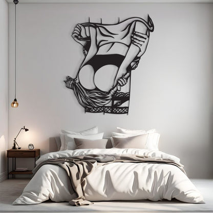 A black metal wall art piece depicting a stylized, abstract female figure in a flowing dress, mounted on a light gray wall above a neatly made bed in a modern bedroom setting.