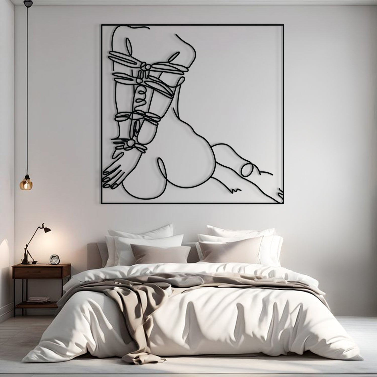 A minimalist black line art print of a crouched figure wrapped in straps, displayed on a light gray wall above a neatly made bed in a modern bedroom setting.
