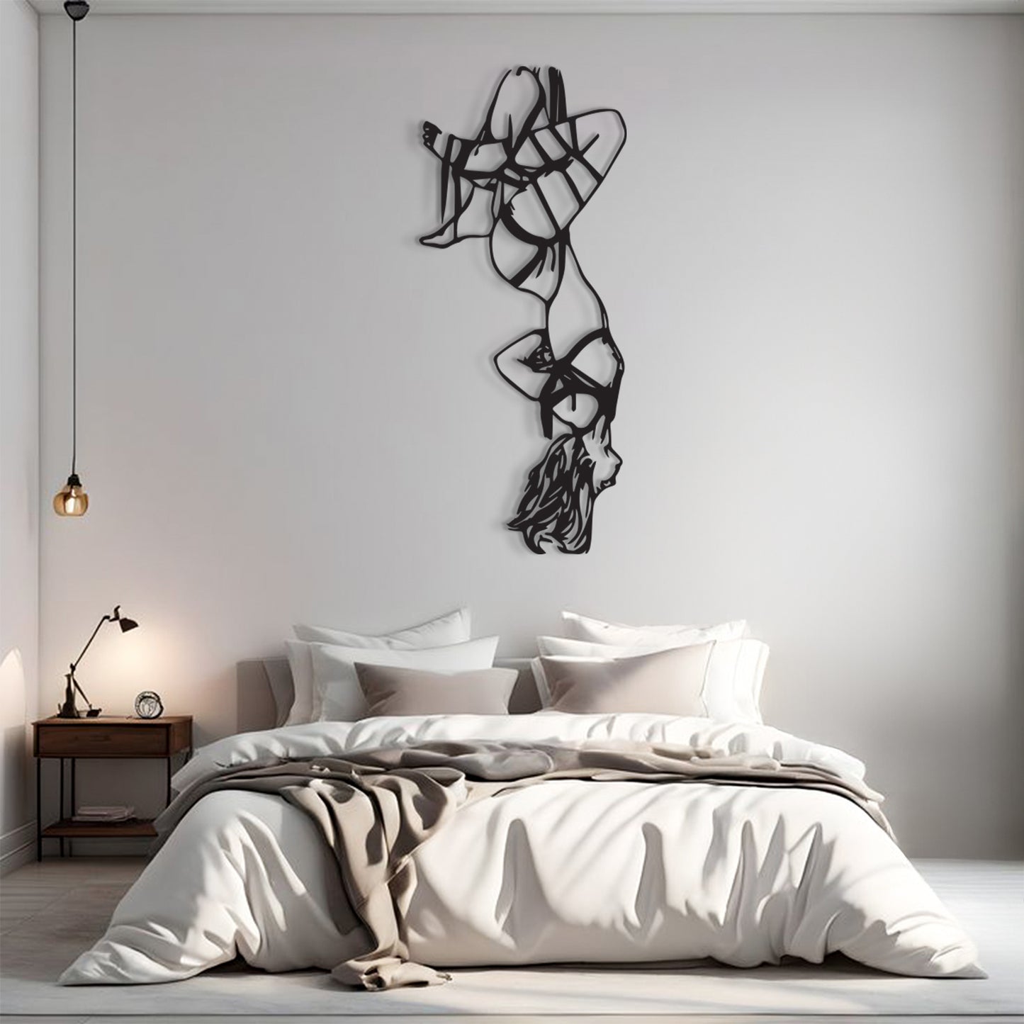 A modern bedroom scene with a bed dressed in white and beige bedding, a small wooden nightstand with a lamp, and a large black abstract wall sculpture mounted on a light gray wall above the bed.