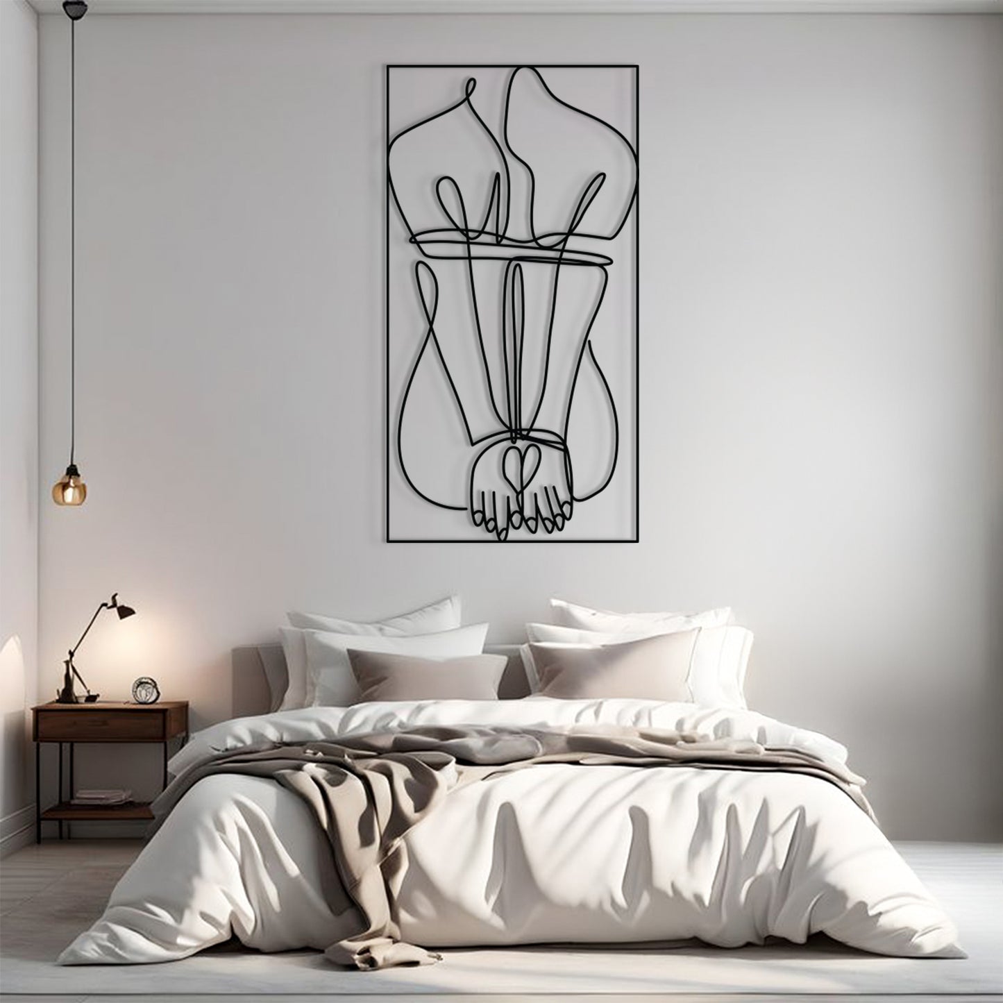 A minimalist black and white continuous line art print of intertwined hands and legs, displayed on a light gray wall above a neatly made bed in a modern bedroom setting.