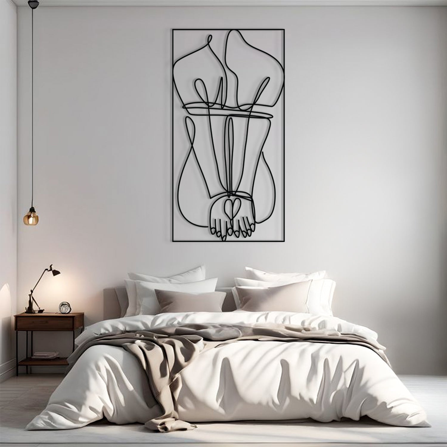 A minimalist black and white continuous line art print of intertwined hands and legs, displayed on a light gray wall above a neatly made bed in a modern bedroom setting.