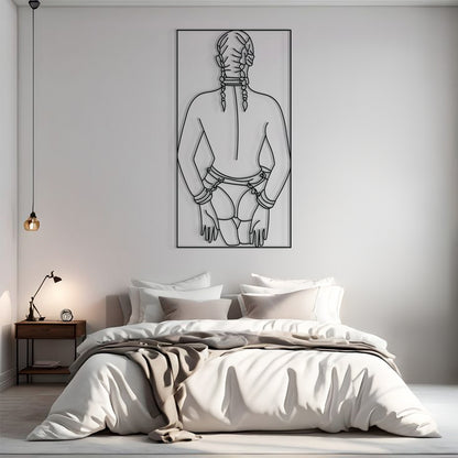 A minimalist black and white line art poster of a person from behind with braided hair, displayed on a light gray wall above a modern bed in a styled bedroom.